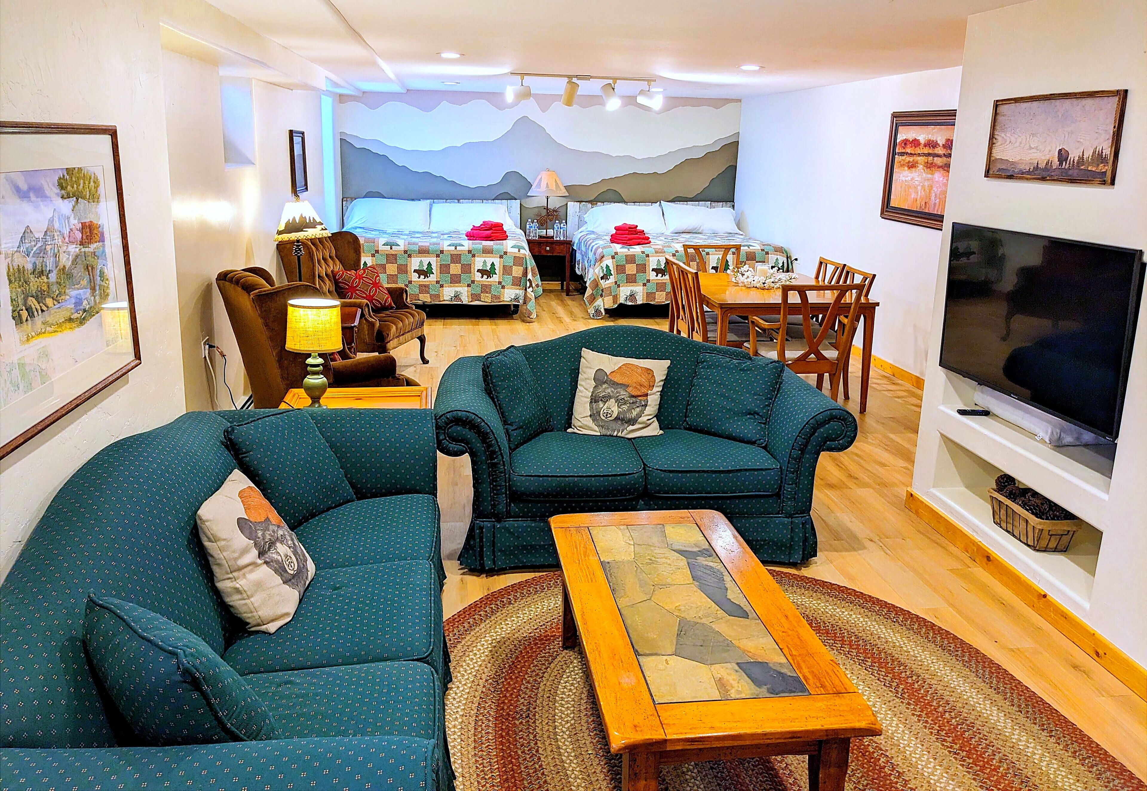 A living room with two sofas, a coffee table, a TV, and a dining area with a table and chairs.