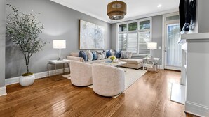 Una sala de estar moderna con un sofá, sillones, una mesa de centro y una planta en maceta.