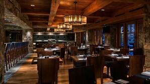 A restaurant with wooden beams, stone walls, and a long dining area with tables and chairs. - RITZ-CARLTON BACHELOR GULCH RESIDENTIAL SUITE located in the Award winning Hotel (Avon)
