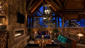 A cozy outdoor seating area with stone walls, a fire feature, and a view of the night sky. - RITZ-CARLTON BACHELOR GULCH RESIDENTIAL SUITE located in the Award winning Hotel (Avon)