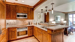 A kitchen with wooden cabinets, stainless steel appliances, a granite countertop, and pendant lighting. - RITZ-CARLTON BACHELOR GULCH RESIDENTIAL SUITE located in the Award winning Hotel (Avon)