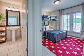 A room with a bunk bed, a sink, a mirror, and a red star-patterned rug. - Walk to Dining,& the Beach–Chic Cottage, Bikes, Kayak, Golf Cart Available (Santa Rosa Beach)