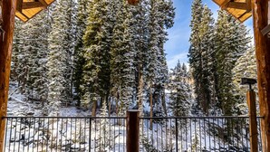 A wooden cabin with a balcony overlooking a snow-covered forest. - Rivamonte by Cottonwood Lodging (Brighton)