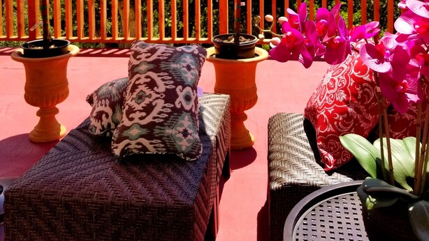 A patio with wicker furniture, a red umbrella, and potted plants. - Carmel-by-the-Sea Escape (Carmel-By-The-Sea)