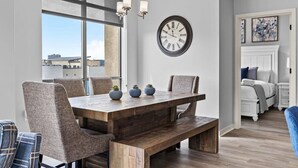 Un coin repas avec une table en bois, des chaises et une horloge murale.