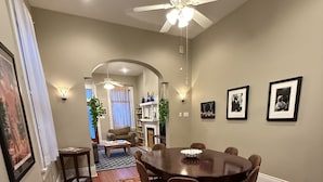 A dining area with a round table, chairs, a ceiling fan, and a patterned rug. - 2-3 N stays - Spacious and Comfy, Walk to Whole Foods, bars and shops, sleeps 12 (New Orleans)