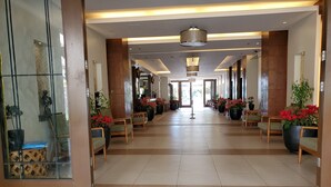 A spacious lobby with a tiled floor, wooden chairs, and potted plants. - N603 Outlook Ridge Residences (Baguio)