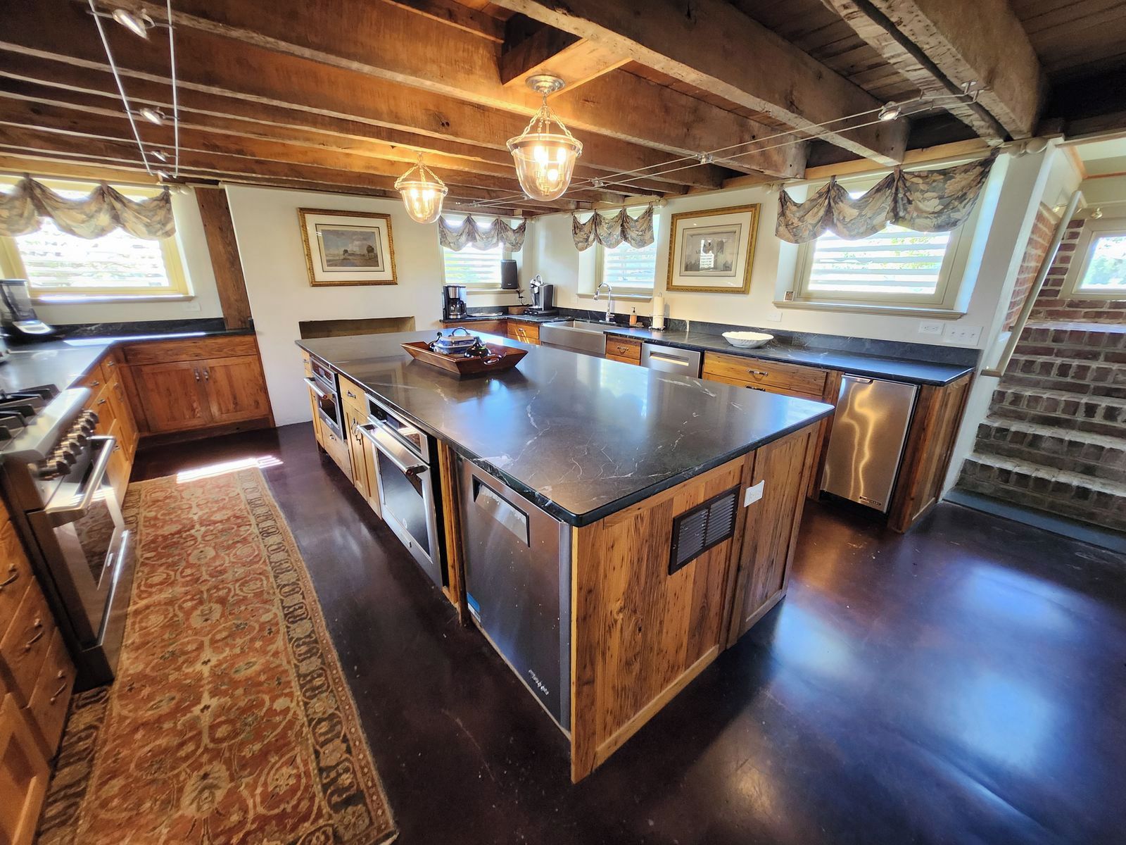 A spacious kitchen with a large island, wooden cabinets, and a built-in oven.