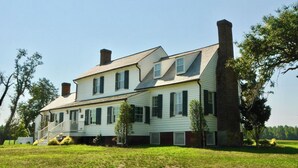 A two-story house with a front porch, a chimney, and a brick chimney on the side. - Cedar Lane Plantation dated back to early 1809 (New Kent)