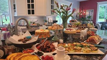 A breakfast buffet with various pastries, fruits, and beverages.