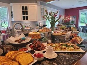 A breakfast buffet with various pastries, fruits, and beverages. - Grayson B&B — ADA Garden & Patio Suite — By Evergreen Equestrian (Monroe)