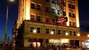 A multi-story hotel with a classic architectural style, featuring a prominent marquee sign on the facade.