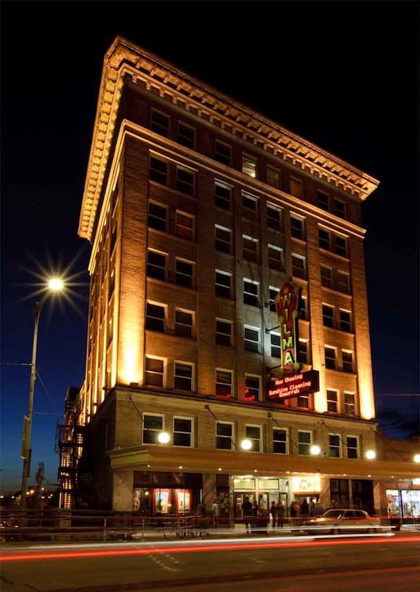 Un hotel de varios pisos con un estilo arquitectónico clásico, que destaca por un llamativo cartel en la fachada.