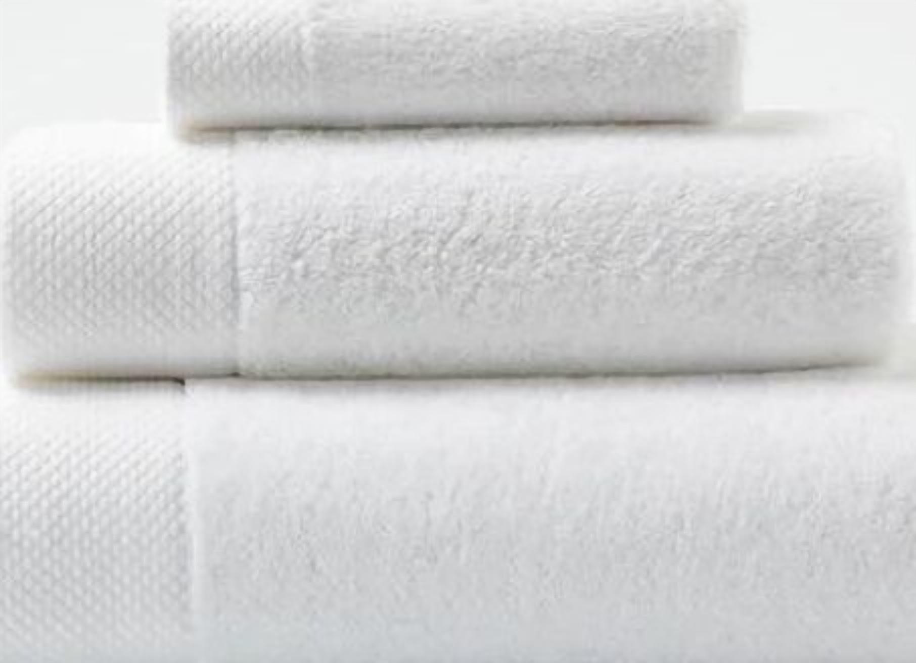 Three neatly folded white towels stacked on top of each other.