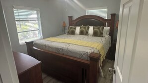 A bedroom with a bed, a ceiling fan, and a window with blinds. - Completely remodeled beautiful waterfront property on canal with dock (Port Charlotte)