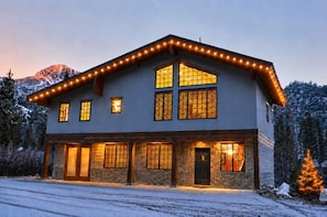 A two-story house with a stone facade, multiple windows, and a snow-covered landscape. - Great Western by Cottonwood Lodging (Brighton)