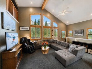 A spacious living room with a large sectional sofa, a flat-screen TV, and a ceiling fan. - Great Western by Cottonwood Lodging (Brighton)