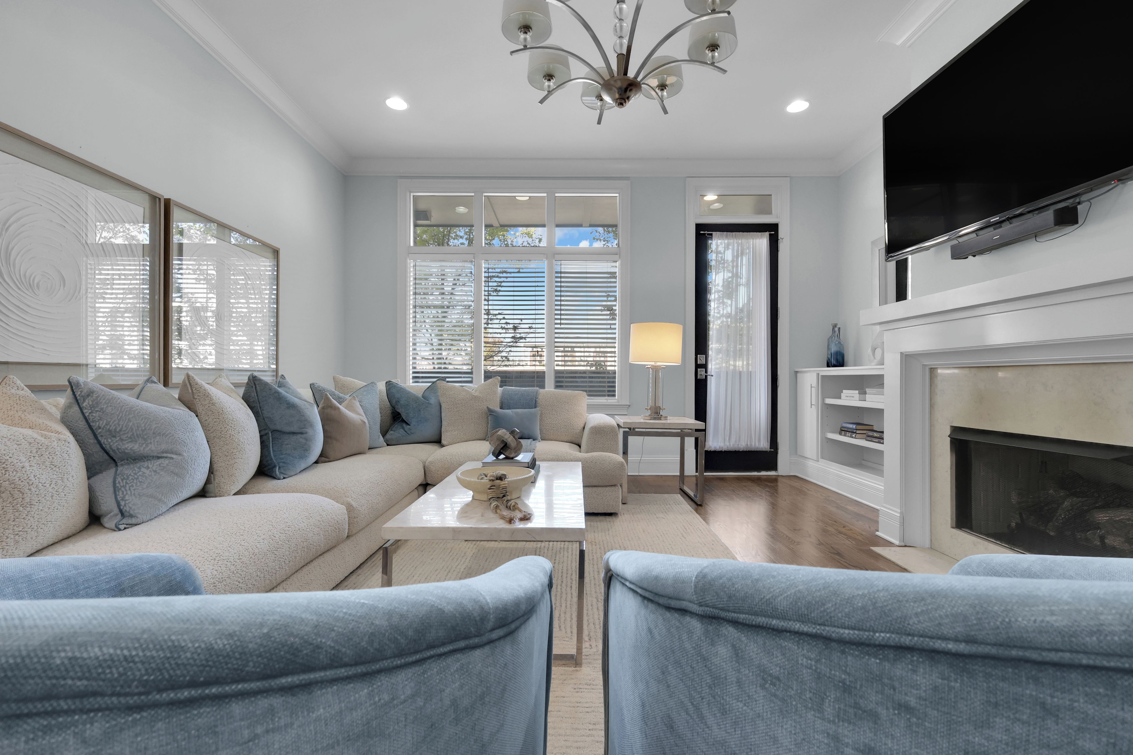 A modern living room with a sofa, chairs, a coffee table, and a fireplace.