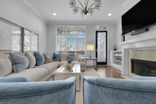 A modern living room with a sofa, chairs, a coffee table, and a fireplace.
