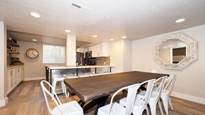 A modern kitchen with white cabinets, a wooden dining table, and white chairs. - Upgraded Suite-Temple Square, Downtown Salt Lake City, Convention Center (Salt Lake City)