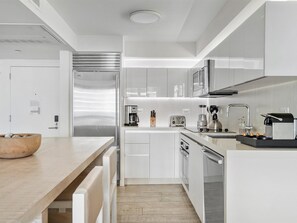 Enjoy cooking and dining in this well-equipped kitchen with a stainless steel refrigerator, coffee maker, and toaster.