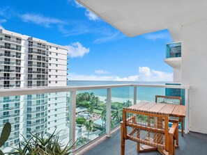 Enjoy breathtaking ocean views from this balcony, featuring a table and chairs.