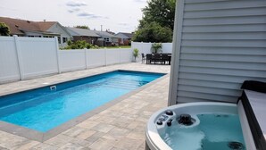 A backyard with a swimming pool and a hot tub. - WALK to Beach, Town of Dewey w/LARGE Heated POOL thru Oct, HOT TUB and fire pit! (Dewey Beach)
