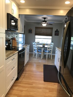 Enjoy meals in the kitchen with a microwave, stainless steel refrigerator, and dining area with a table and chairs.