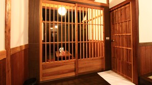 Ein traditioneller japanischer Raum mit Schiebetüren, Holzboden und einem kleinen Tisch mit Wasserkocher.