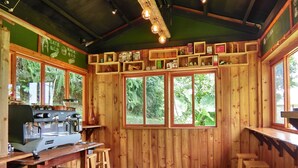 Ein Holzinnenraum mit Barbereich, Holzstühlen und einer Kaffeemaschine.