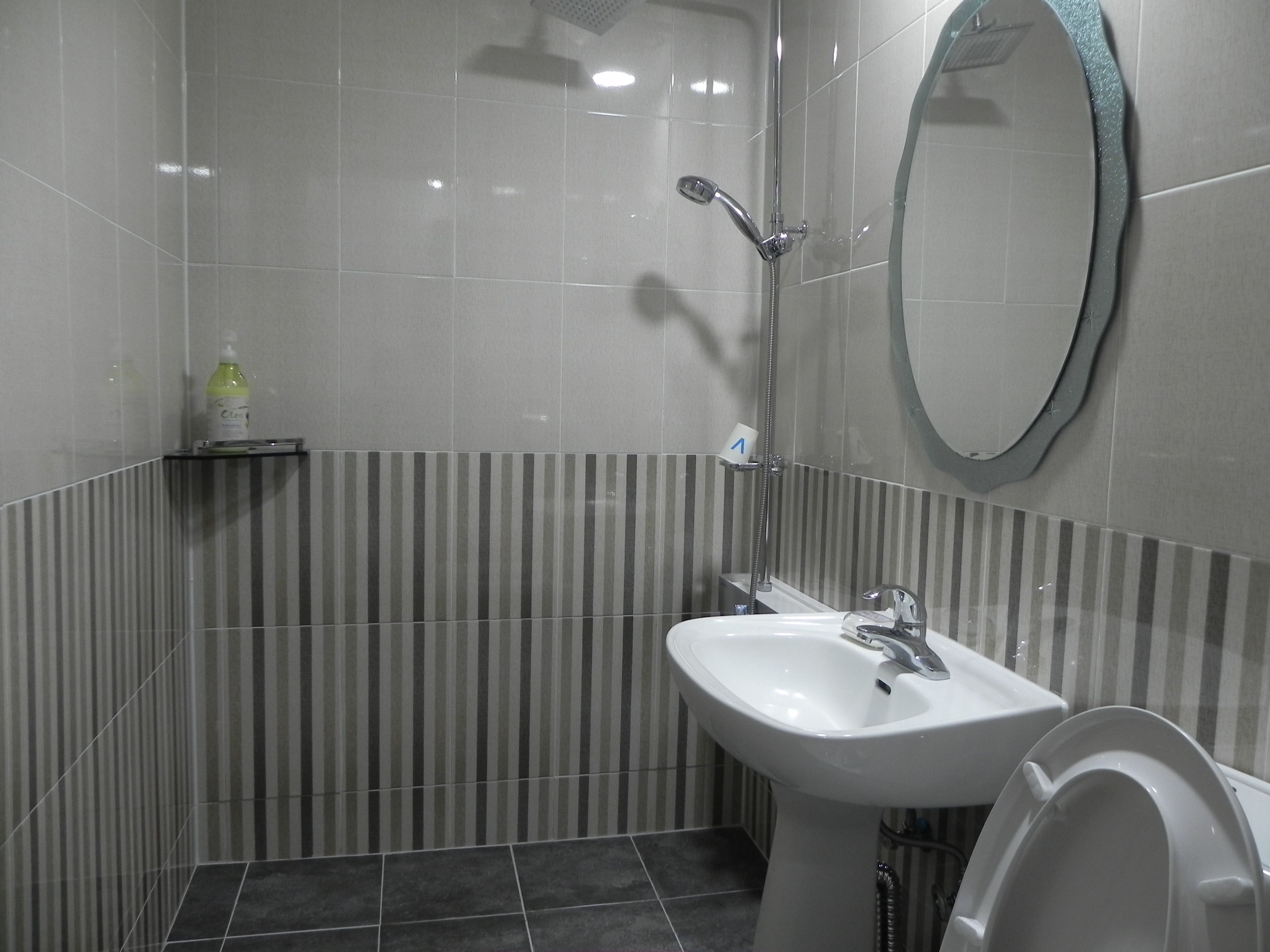 Ein Badezimmer mit Waschbecken, Spiegel und Dusche.