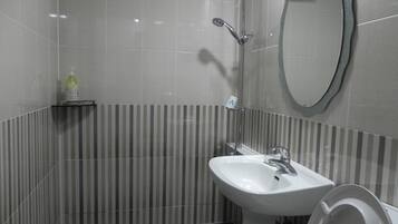Ein Badezimmer mit Waschbecken, Spiegel und Dusche.