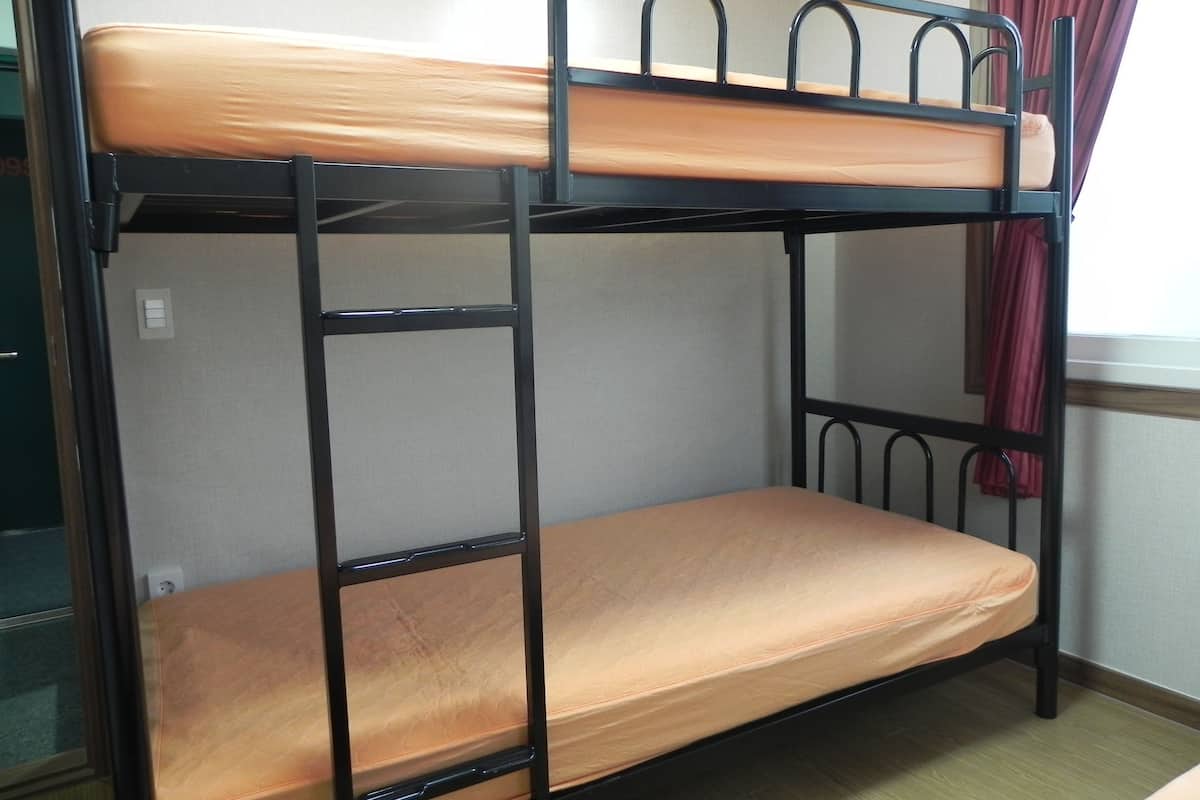 A bunk bed with a mattress and metal frame.