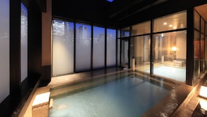 A modern indoor swimming pool with large windows and a city view. - Candeo Hotels Tokyo Shimbashi (Tokyo)