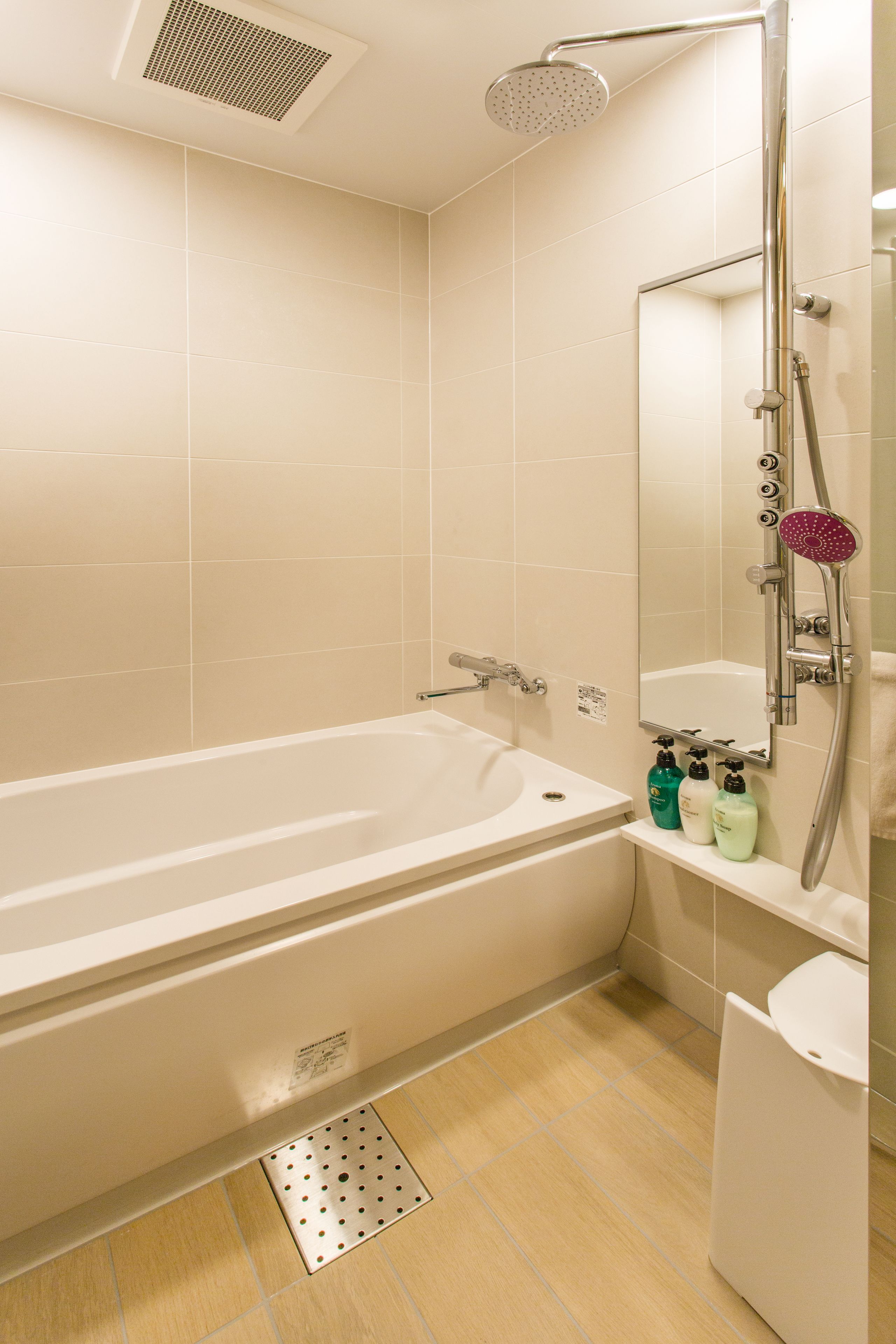 A modern bathroom with a bathtub, a shower, and a toilet.