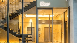 Ein Hotel Eingang mit modernem Design, inklusive Treppe, Glasüren und einem Schild für Hotel Musse.