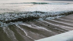 A beach with waves and a sunset in the background. - Oceana Lodge (Baler)
