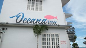 The exterior of Oceana Lodge with a clear sign indicating the entrance. - Oceana Lodge (Baler)