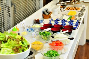 Ein reichhaltiges Buffet mit verschiedenen Speisen, darunter Salate, Käse und Gemüse.
