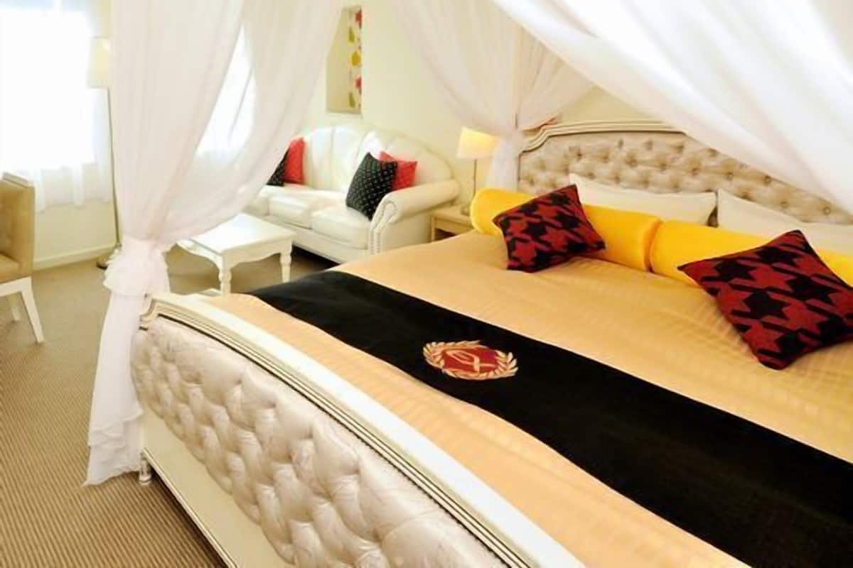 A bed with a canopy, a tufted headboard, and a bedside table.