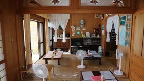 Ein traditioneller japanischer Raum mit Tatami-Böden, Holzmöbeln und verschiebbaren Türen.