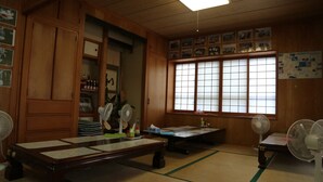 Ein traditioneller japanischer Raum mit Tatami-Böden, Holzmöbeln und Shoji-Schirmen.