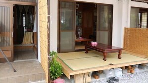 Ein traditioneller japanischer Raum mit Tatami-Böden, einem niedrigen Holztisch und verschiebbaren Türen.