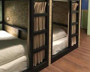 A bunk bed room with wooden frames and beige curtains. - Tourist Bunny - Hostel (New Taipei City)