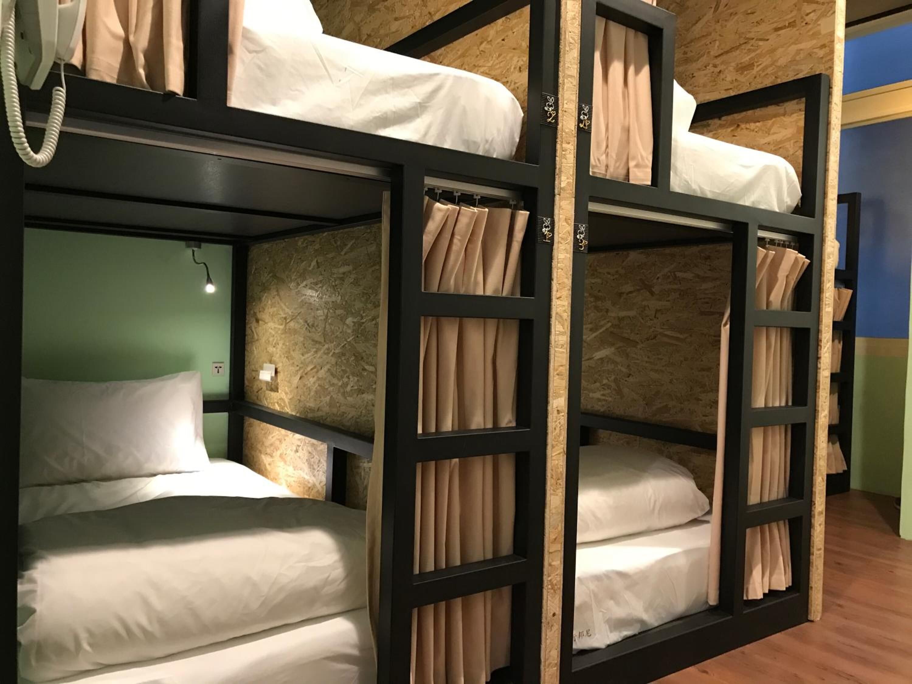 Habitación con literas y un teléfono a la izquierda.