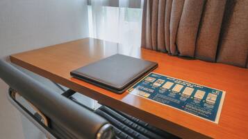 A wooden table with a laptop and a blue informational card.