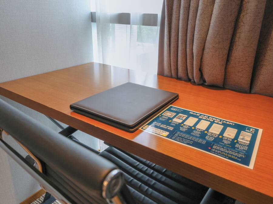 A wooden table with a laptop and a blue informational card.