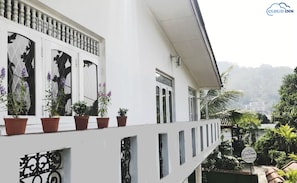 A white building with a balcony, potted plants, and a sign for Cloud Inn. - Cloud Inn Kandy (Kandy)