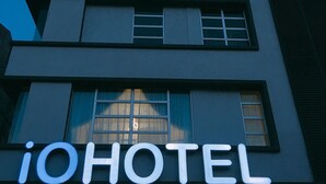 En moderne bygning med et skilt, der viser "iHOTEL", der angiver et hotel.