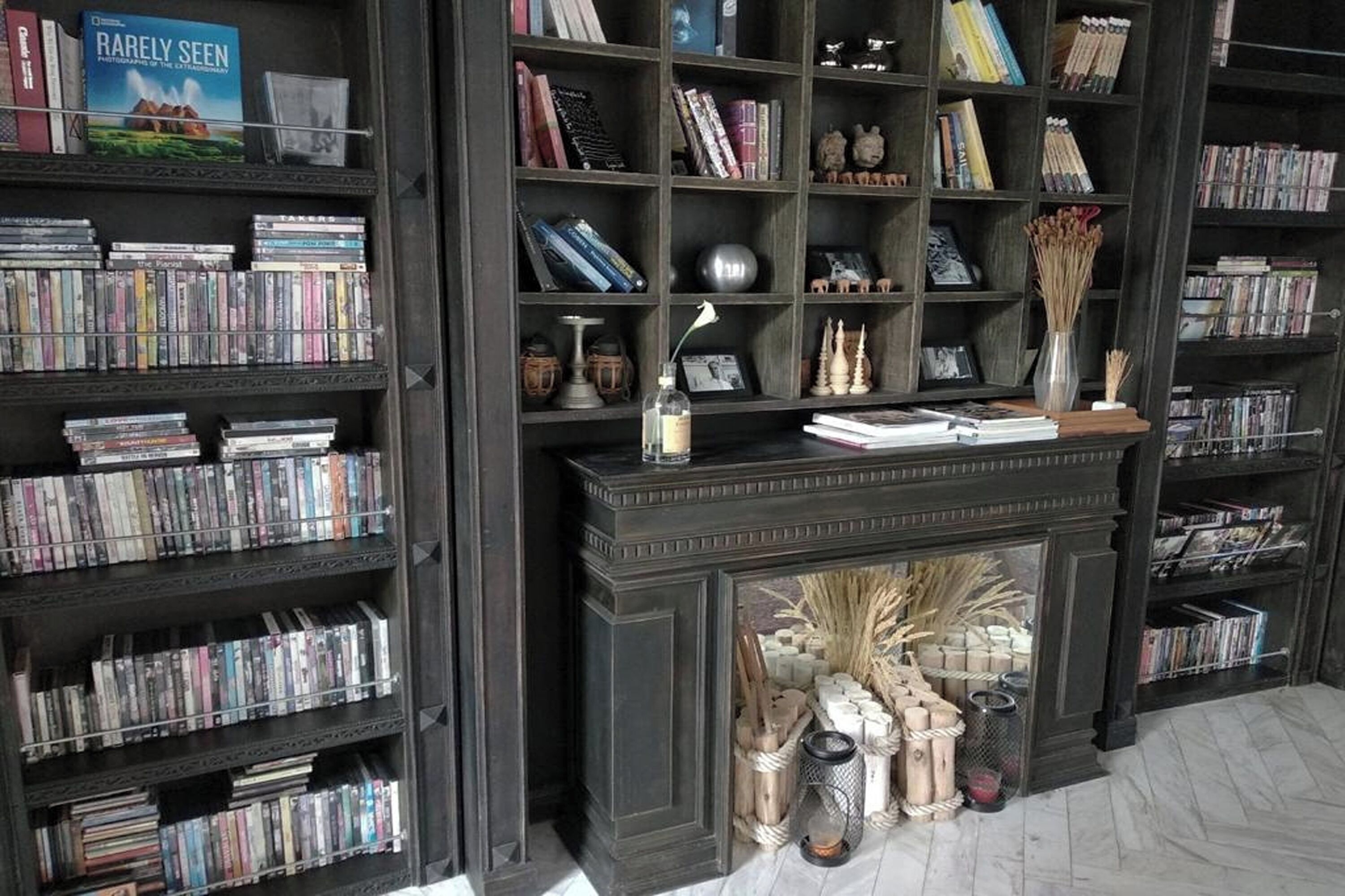 A library with bookshelves, a fireplace, and decorative items.